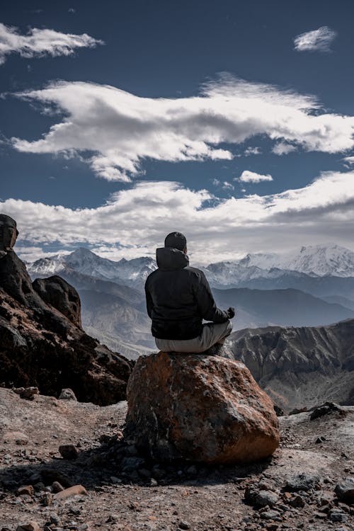 Man Sitting on a Rock in the Mountains