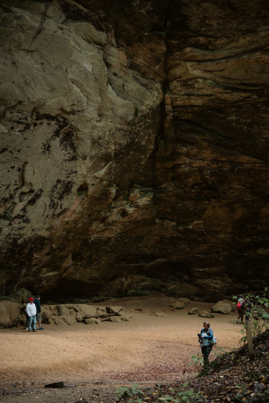 Visitors exploring the magnificent Ash Cave's towering rock formations in Ohio's Hocking Hills.