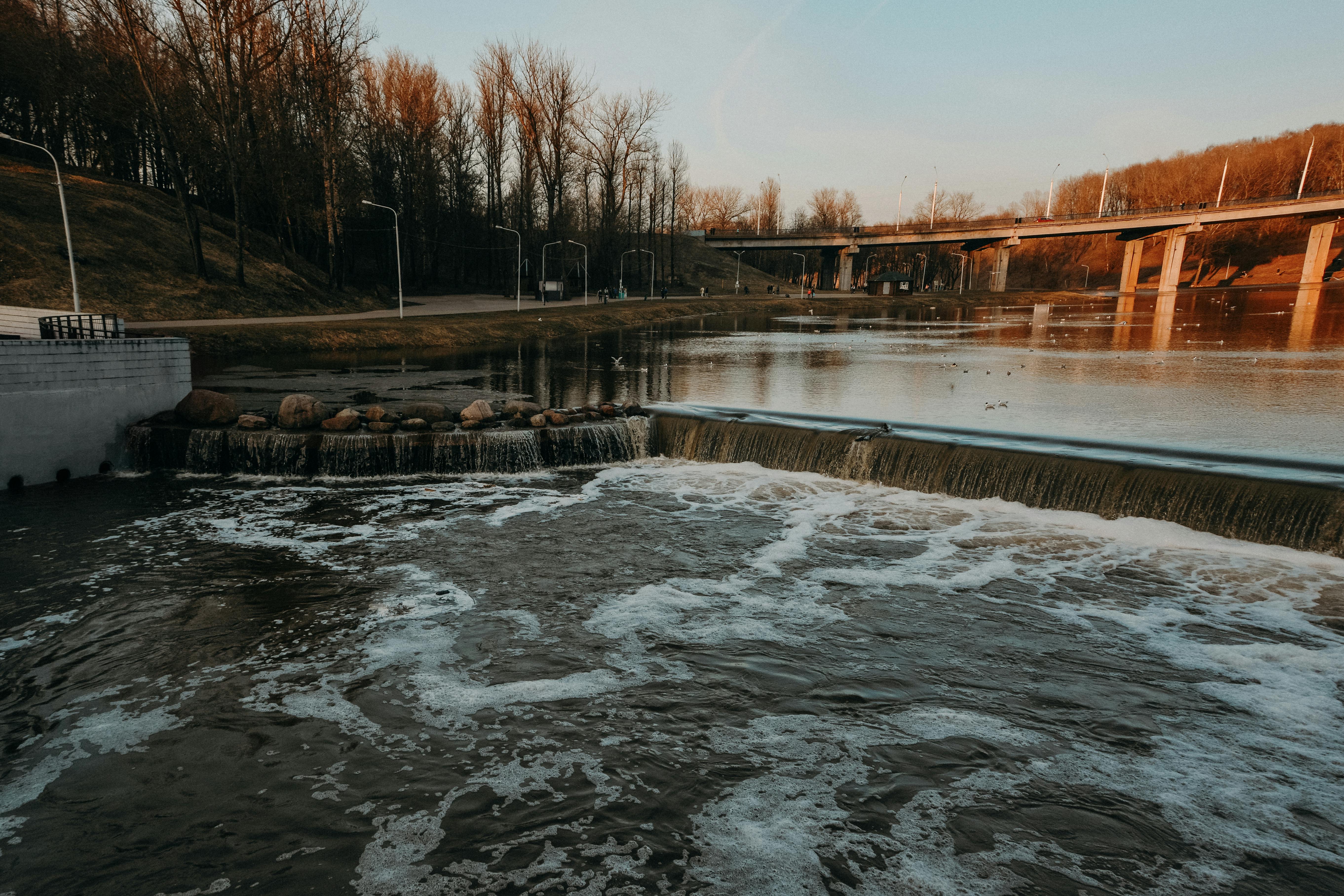 日落时分，公园里有一条河流，一座桥和一条瀑布