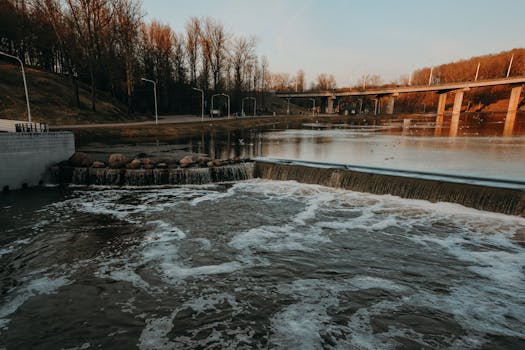 日落时分，公园里有一条河流，一座桥和一条瀑布