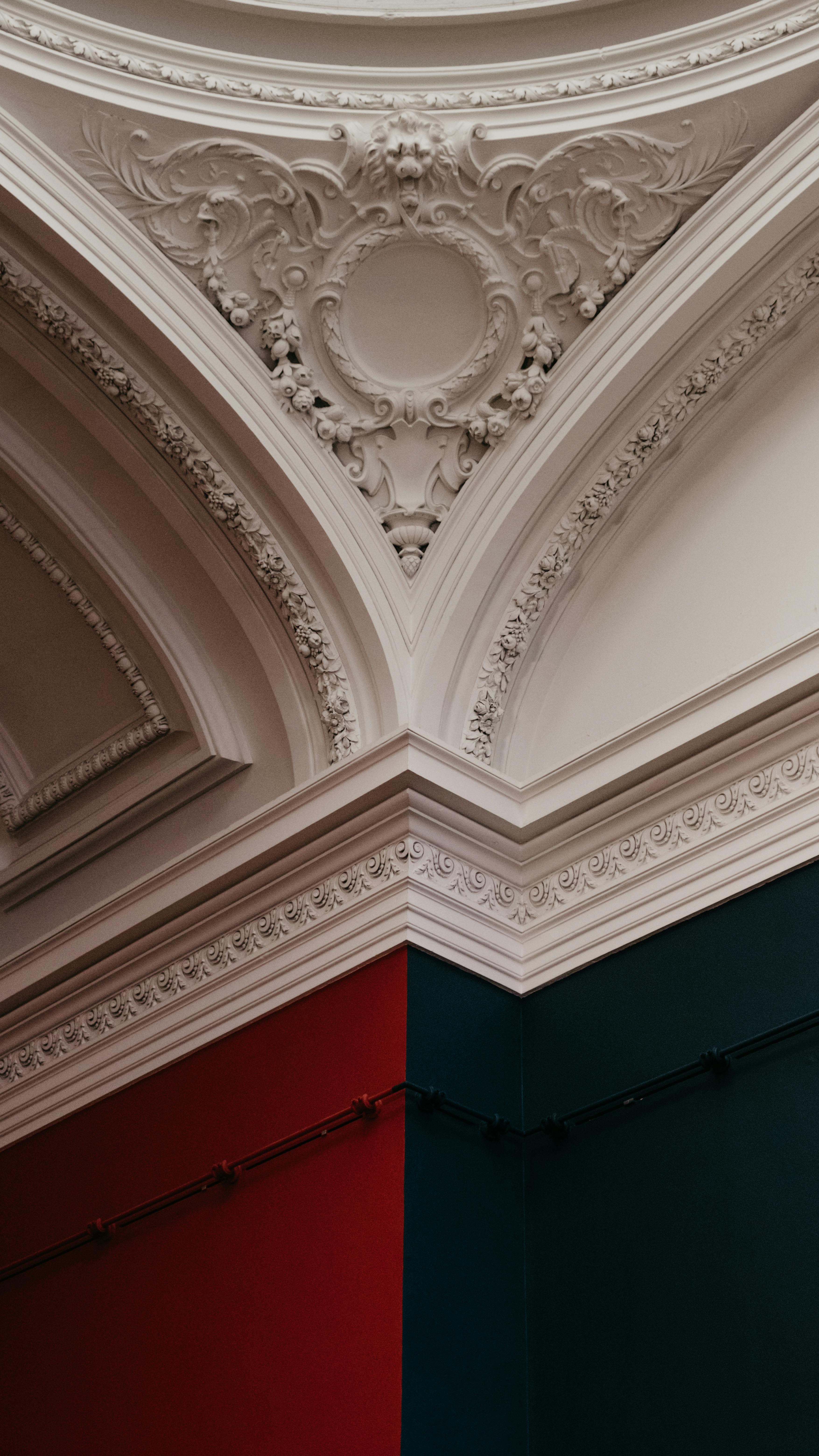 Ornate interior ceiling with intricate molding and contrasting wall colors.