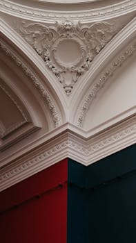 Ornate interior ceiling with intricate molding and contrasting wall colors.