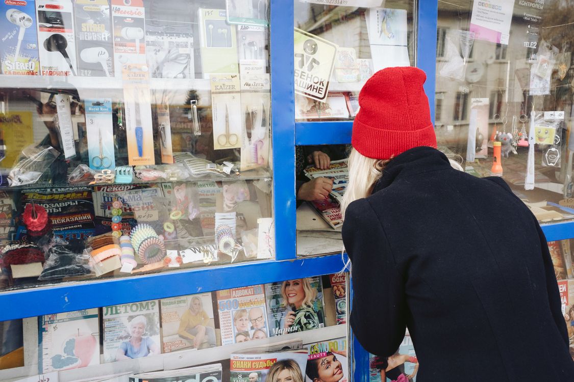 Woman Buying a Newspaper in a Kiosk · Free Stock Photo