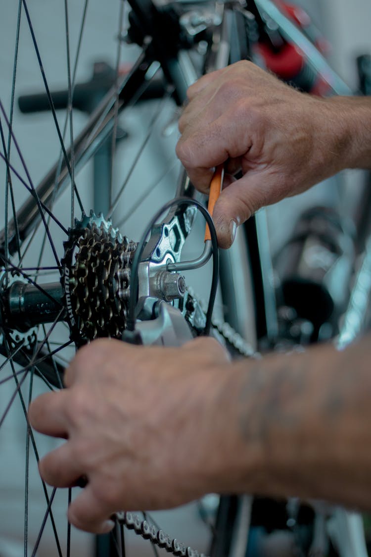 Close-up Of A Mechanic Fixing A Bike