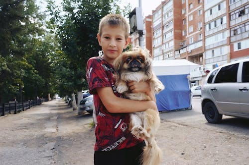 Free Young Boy Holding a Dog Stock Photo