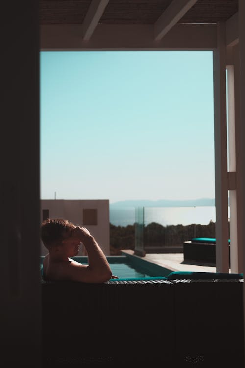 Woman in Black Tank Top Sitting on Swimming Pool