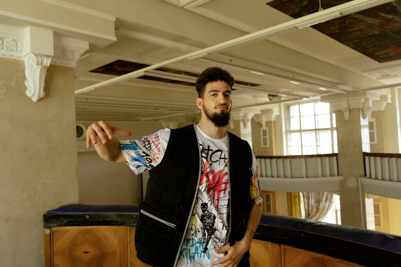 Bearded man with urban style, posing confidently in a modern indoor space.
