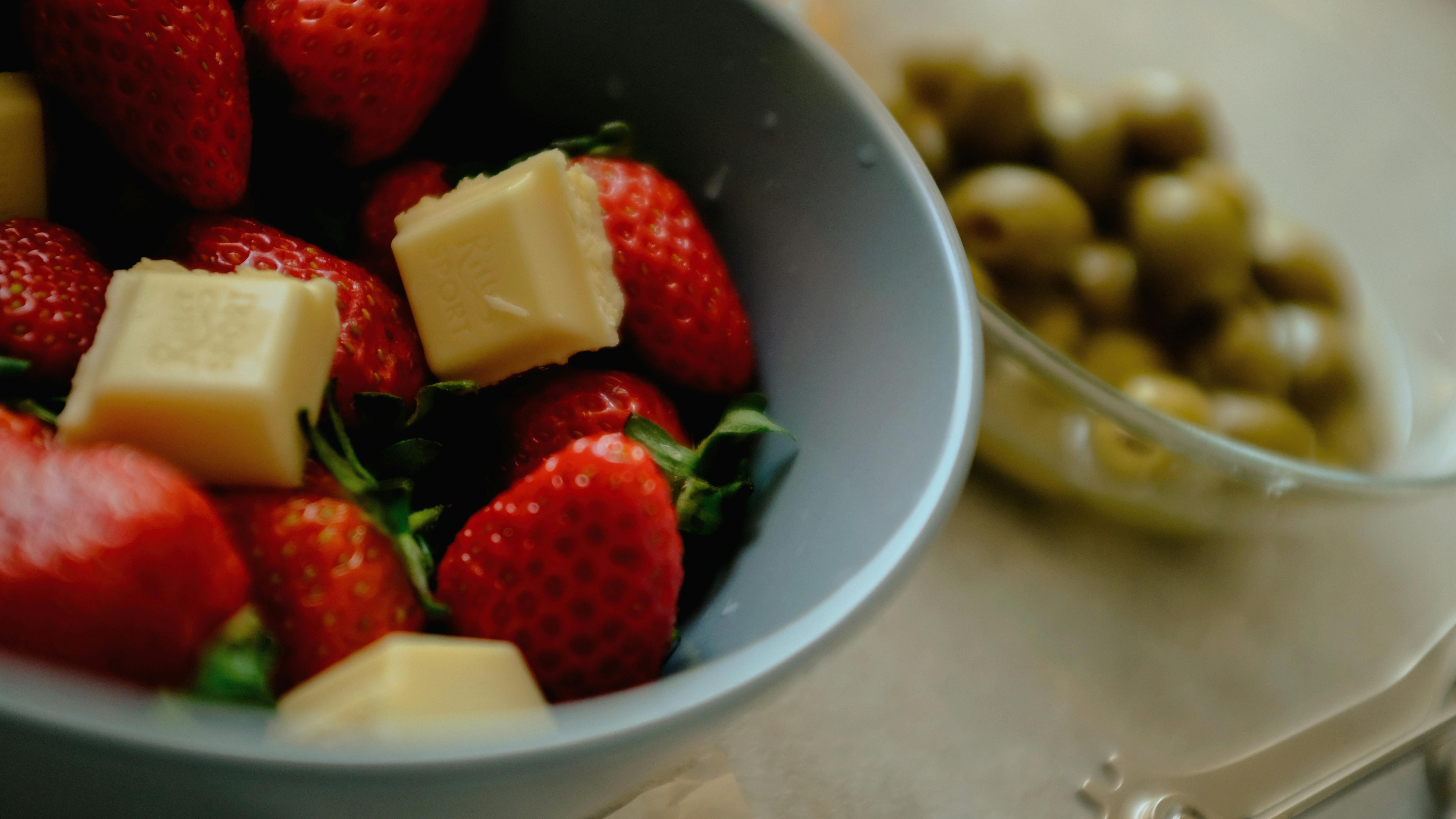 Delicious strawberries with chunks of white chocolate in a bowl, perfect for dessert ideas.