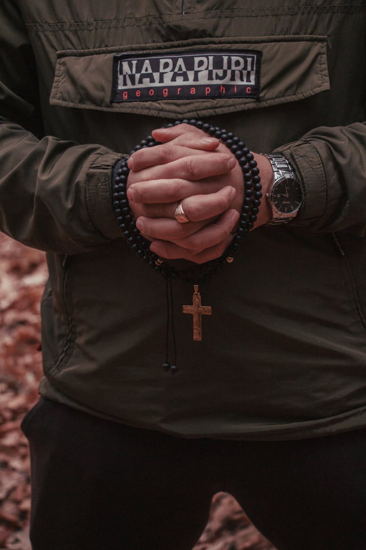 A Rosary Wrapped Around A Person's Clasped Hands