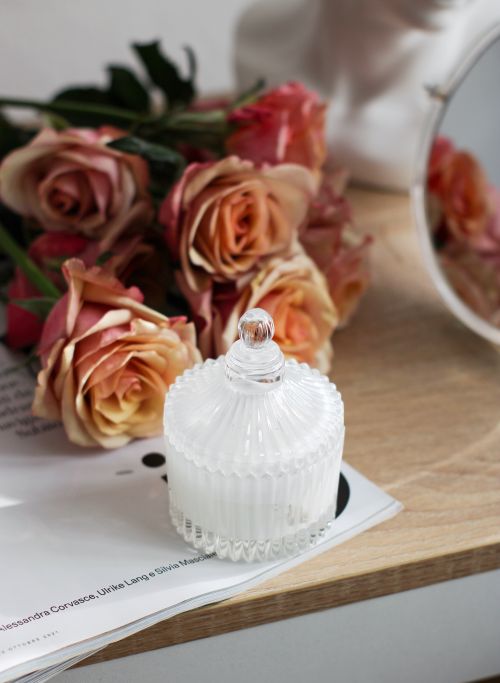 Free Stylish arrangement of tea roses with a crystal candle holder on a wooden table, offering elegance. Stock Photo