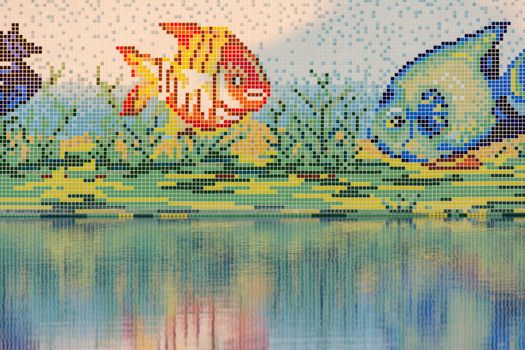 Vibrant mosaic art depicting fish above a reflective water surface.