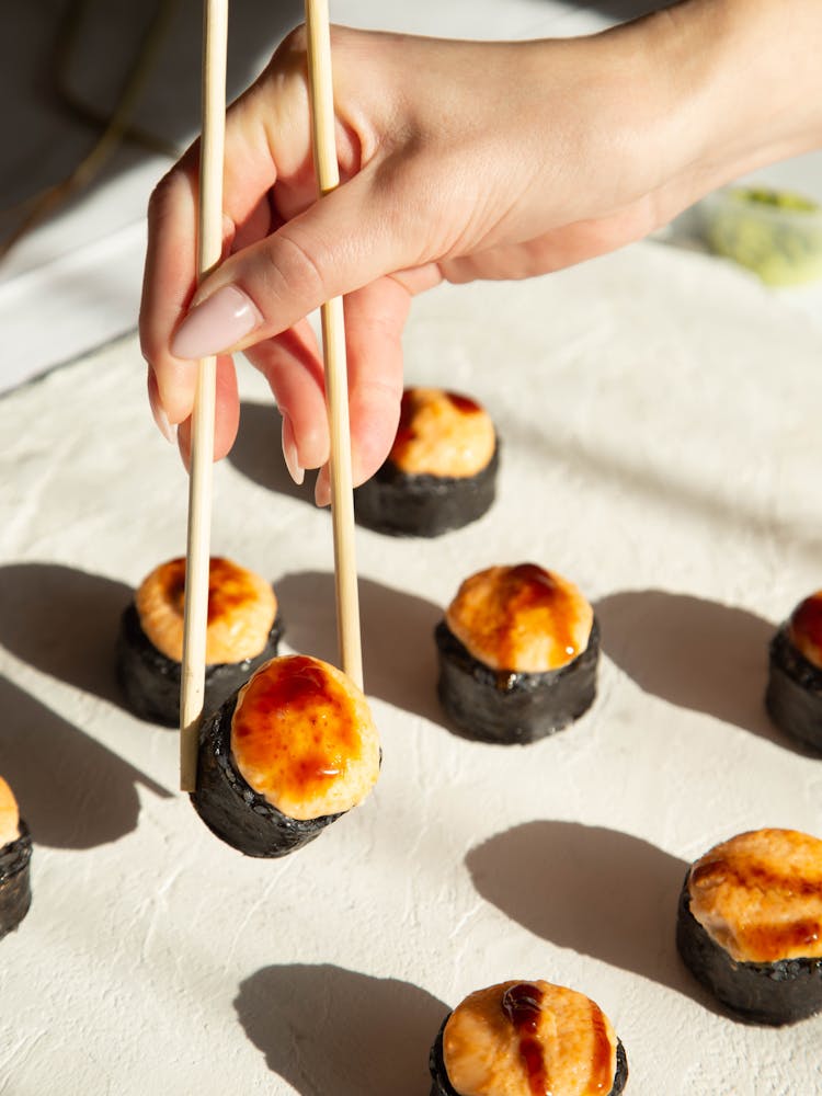 Hand Holding Chopsticks Grabbing Sushi