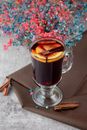 Mulled Wine with Oranges and Cinnamon in Glass on Table