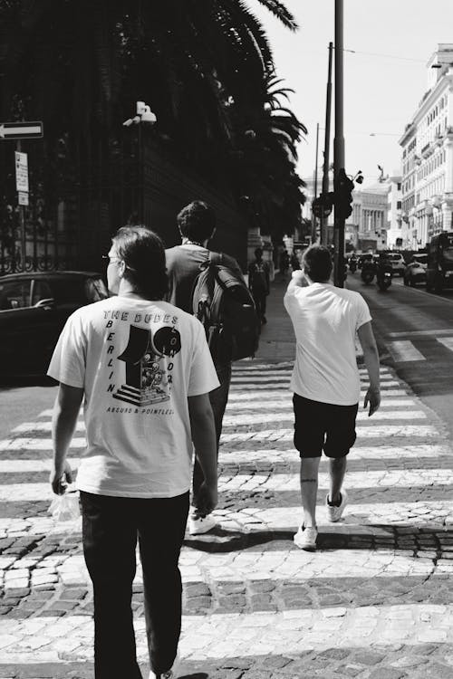 Free Man in White Crew Neck T-shirt and Black Shorts Walking on Pedestrian Lane Stock Photo