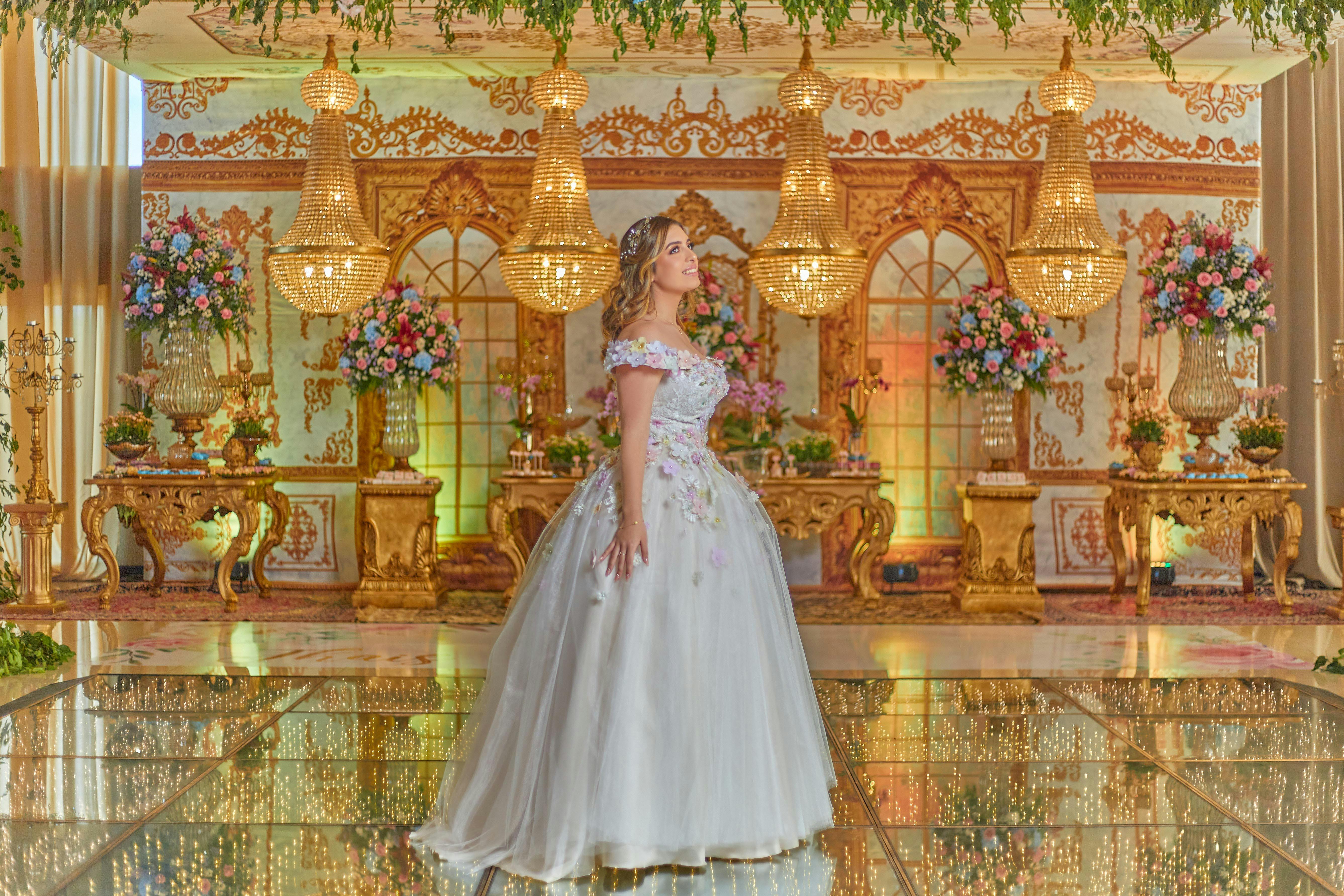 a woman wearing a white gown inside a room decorated with flowers
