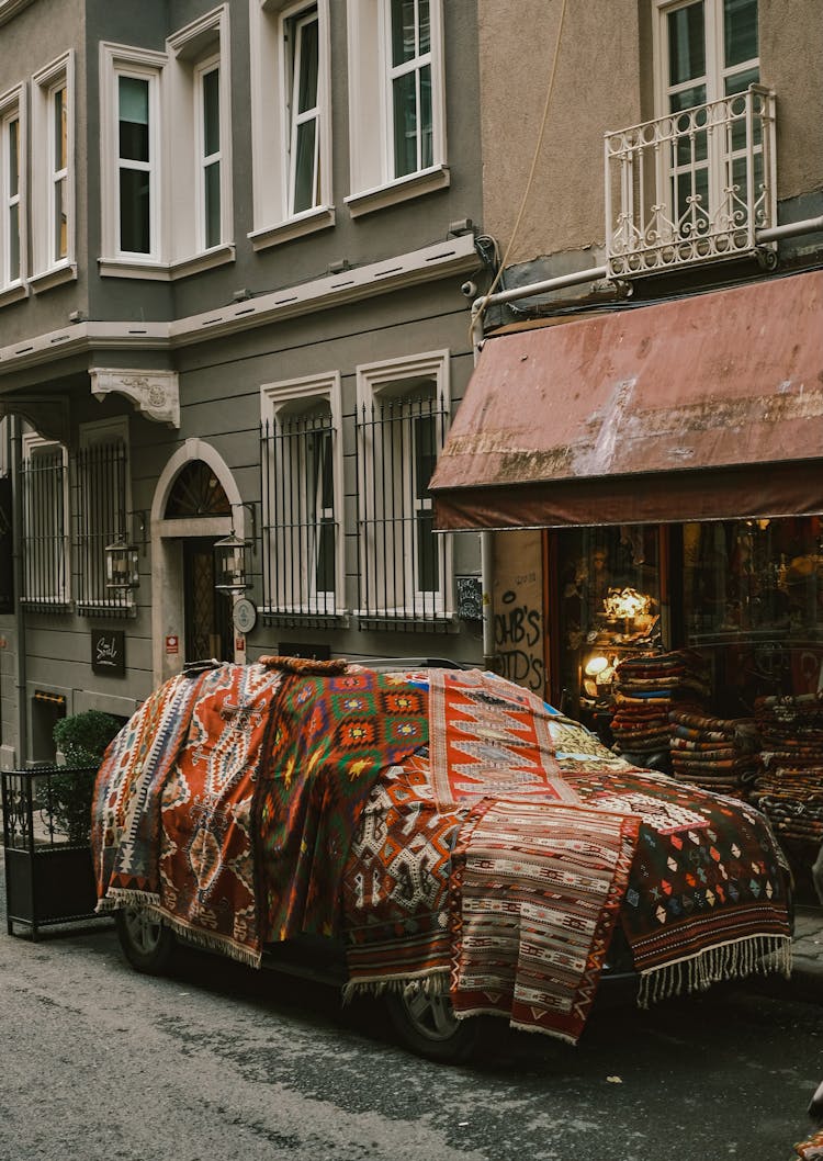 A Car By An Old Carpet In Front Of A Building