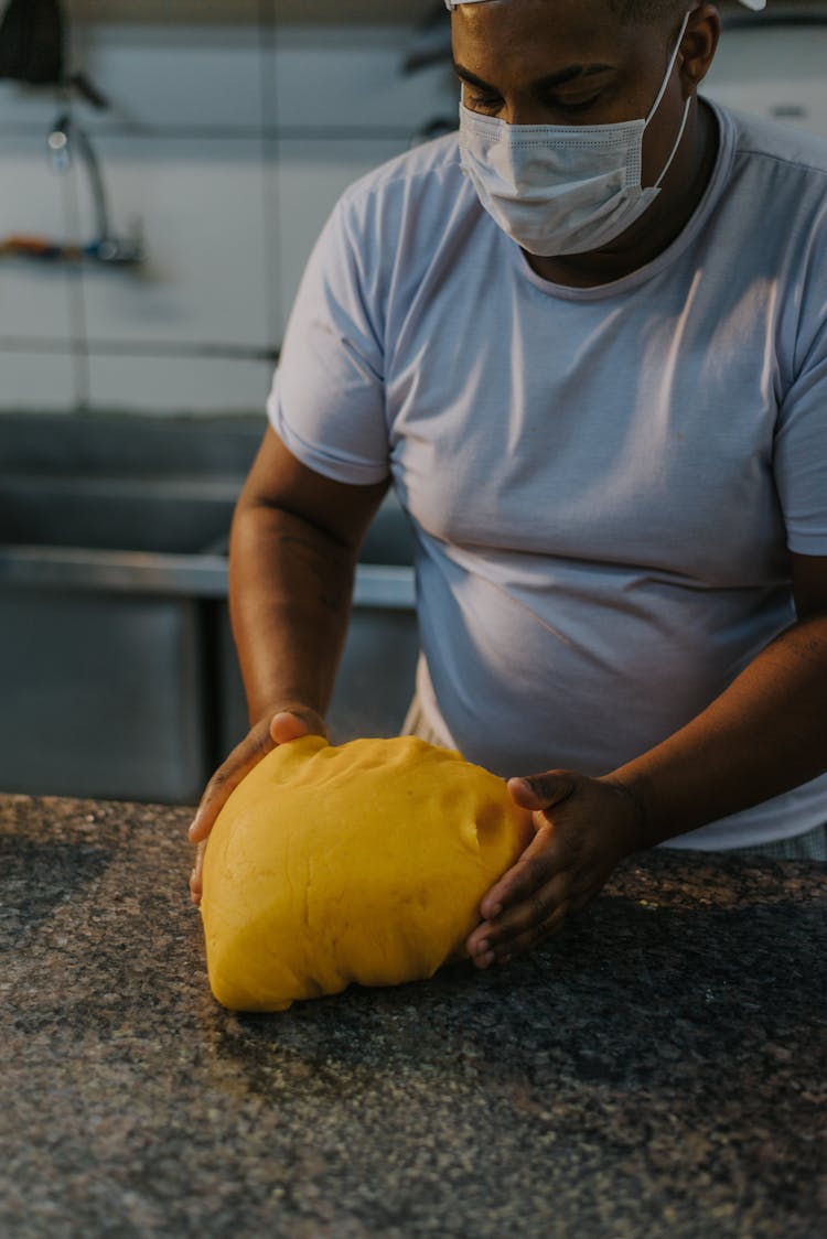 Person In White Crew Neck Shirt Molding The Dough