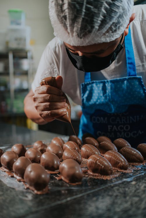 A Shot of a Worker Decorating Chocolate Products