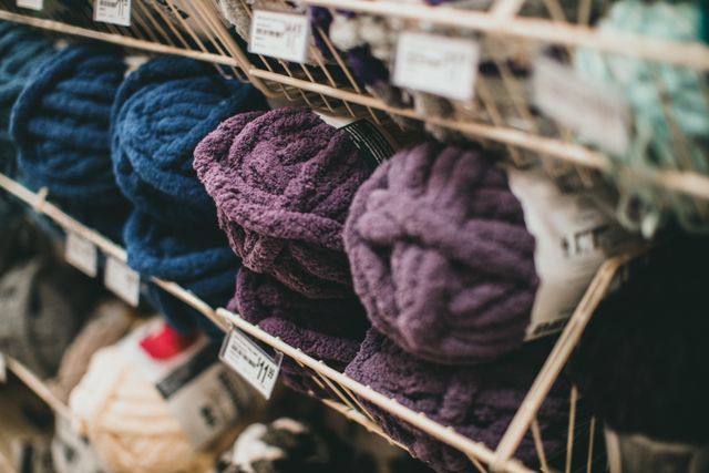 Pelotes de laine colorées rangées sur des étagères dans une boutique de laine