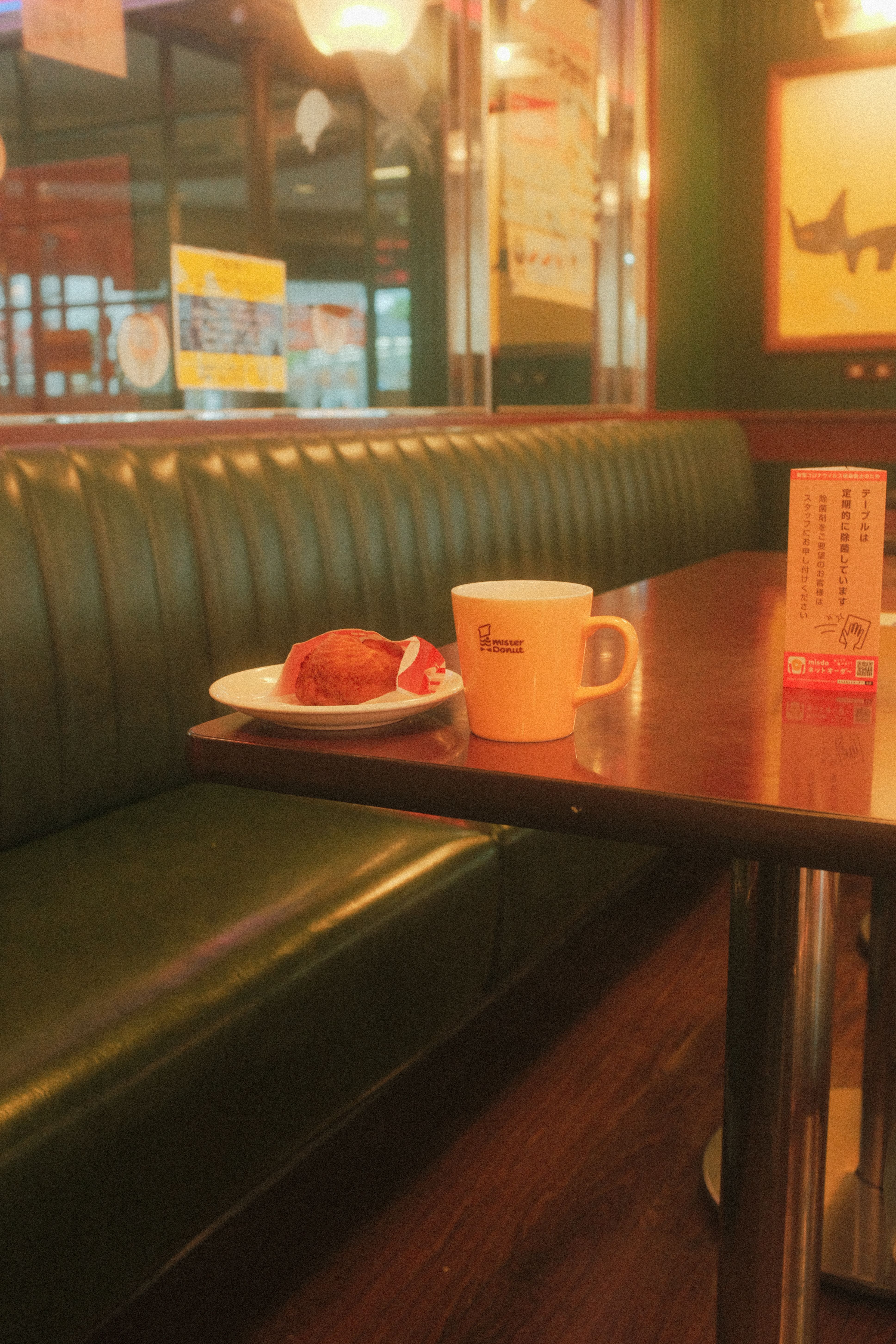 Warm cafe setting featuring a mug of coffee and pastry on a table.