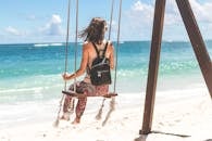 Woman Sitting on Seashore Swing