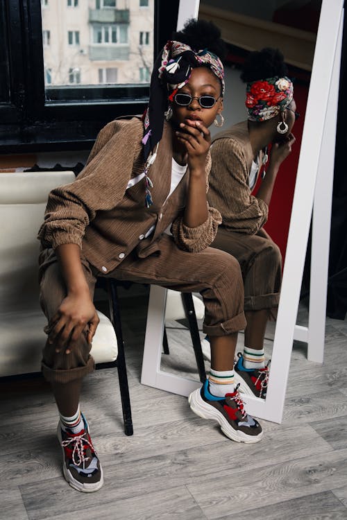 Woman Wearing brown outfit next to a mirror