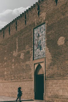 A visitor approaches the historic Karim Khan Citadel entrance in Shiraz.