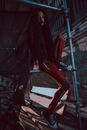 Woman in Red Costume Sitting on Scaffolding