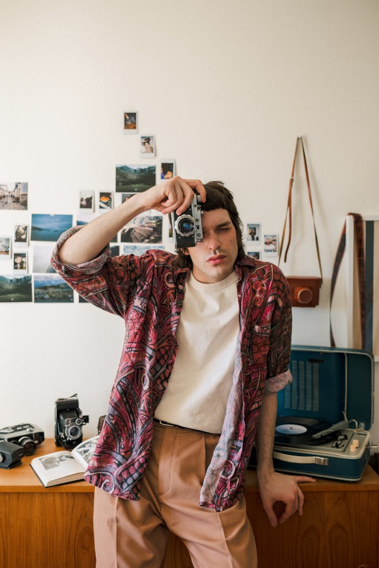 Male Photographer Taking Photo At Home With Analog Camera