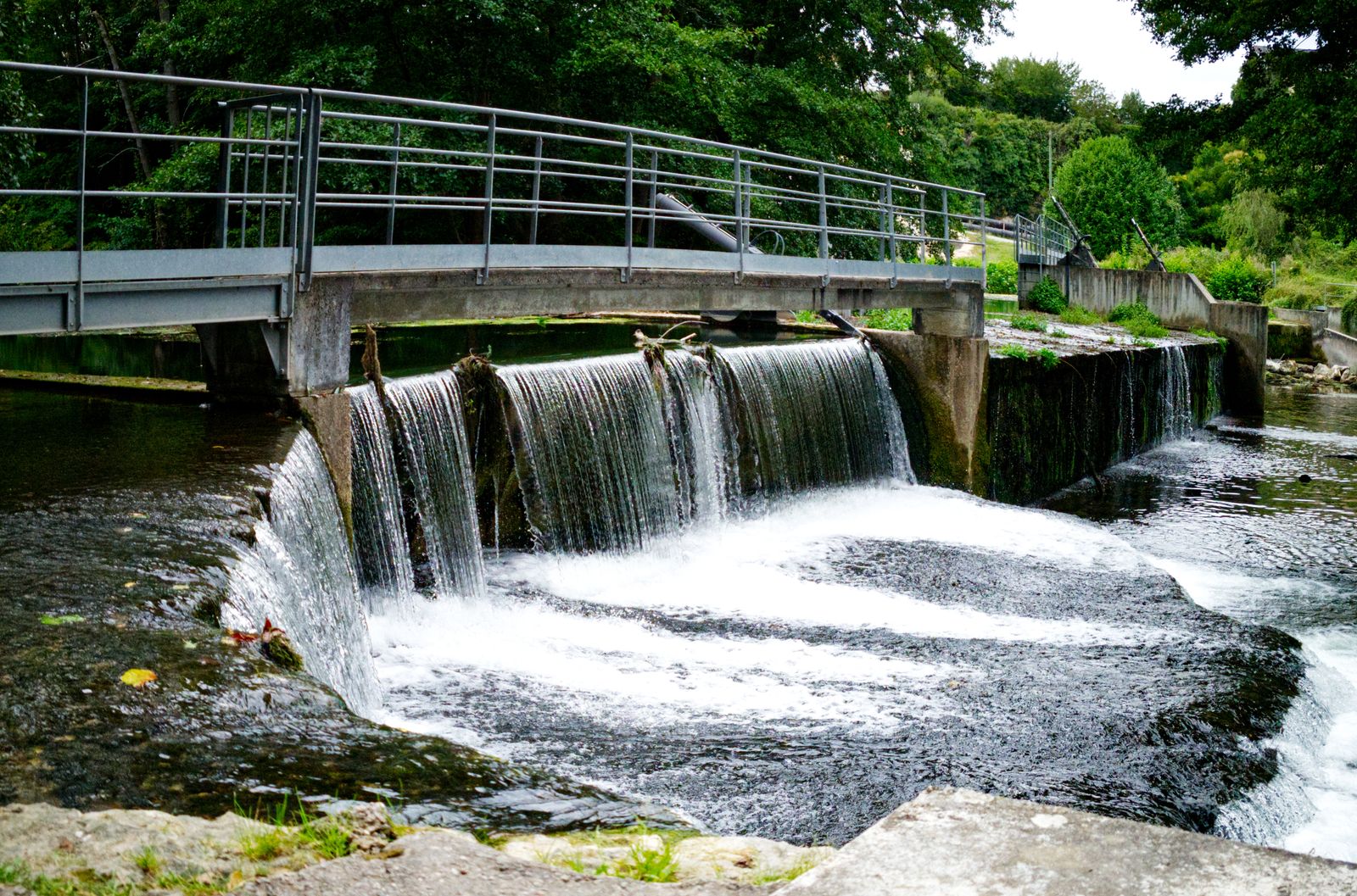 Petit seuil en cascade sous une passerelle métallique