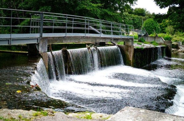 Petit seuil en cascade sous une passerelle métallique