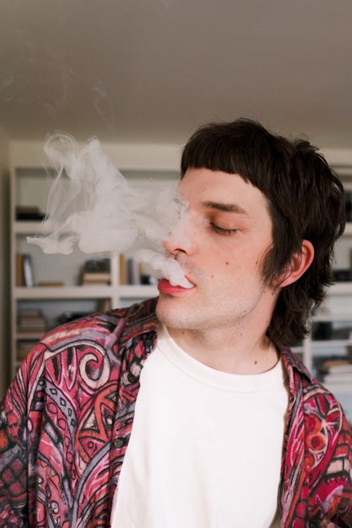 Young Man Exhaling Smoke from His Mouth