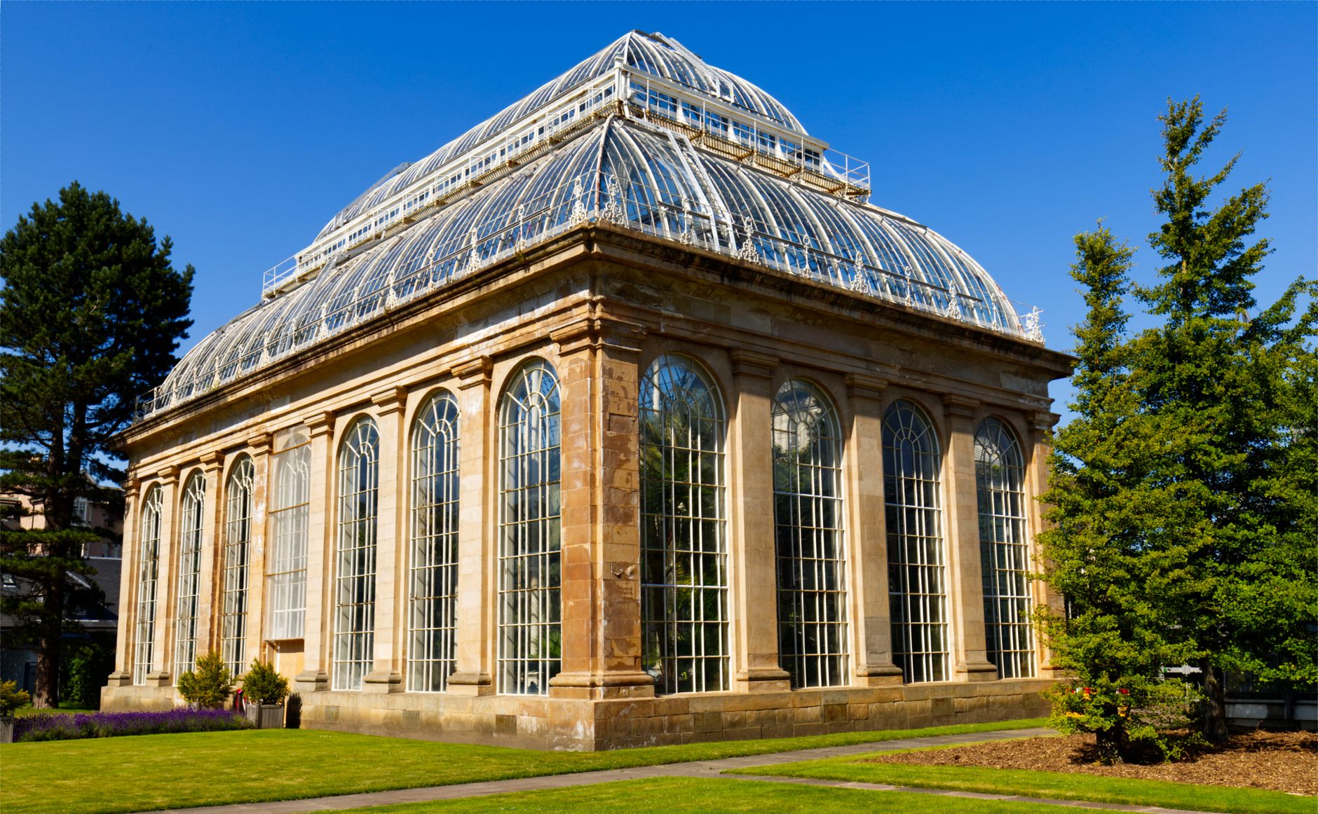 Explore the beautiful Victorian greenhouse at Edinburgh's Royal Botanic Garden on a sunny day.
