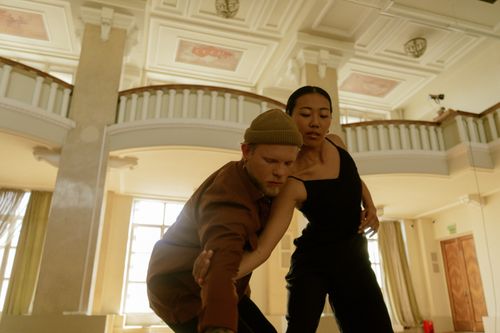 Free Two dancers perform a contemporary routine in a spacious, elegant hall. Stock Photo