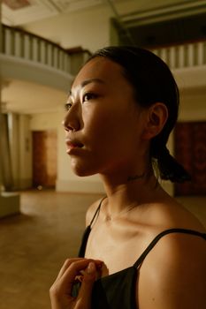Close-up of a thoughtful woman in a serene indoor setting, highlighting her profile and natural beauty.