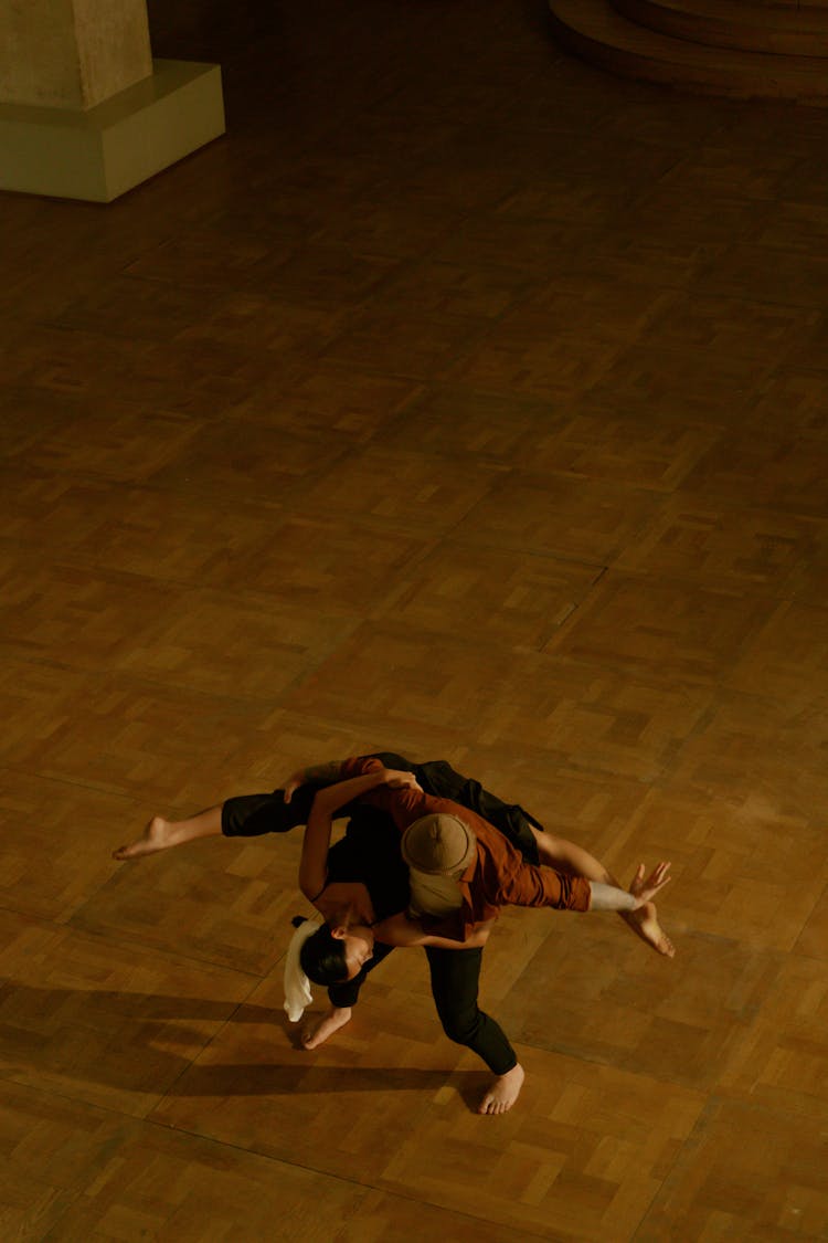 A Man Carrying A Woman Doing A Leg Split