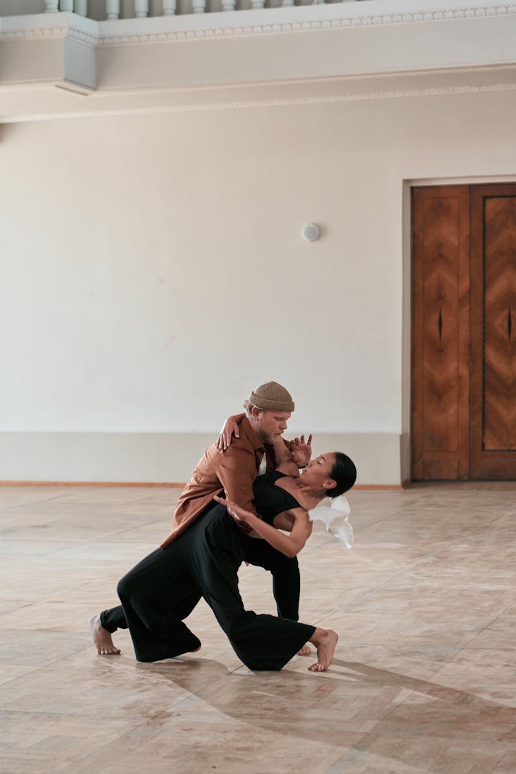 Man Supporting The Woman While She Is Leaning Backward