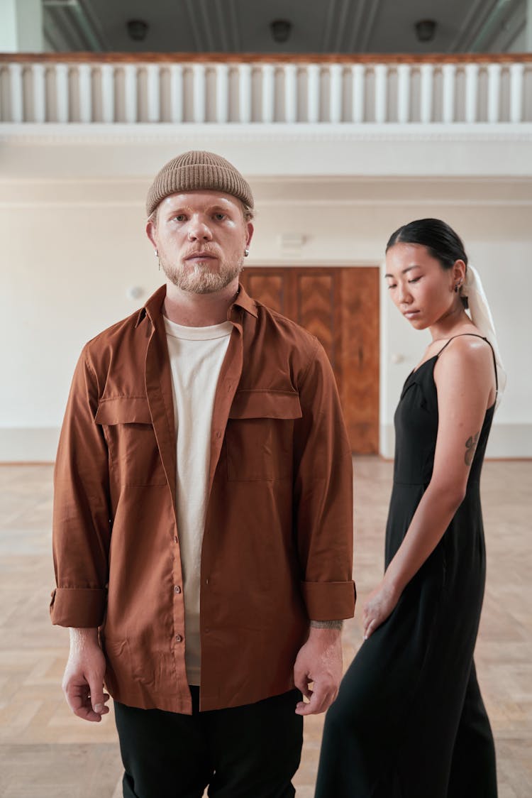 Woman Standing Beside The Man In Brown Long Sleeves 