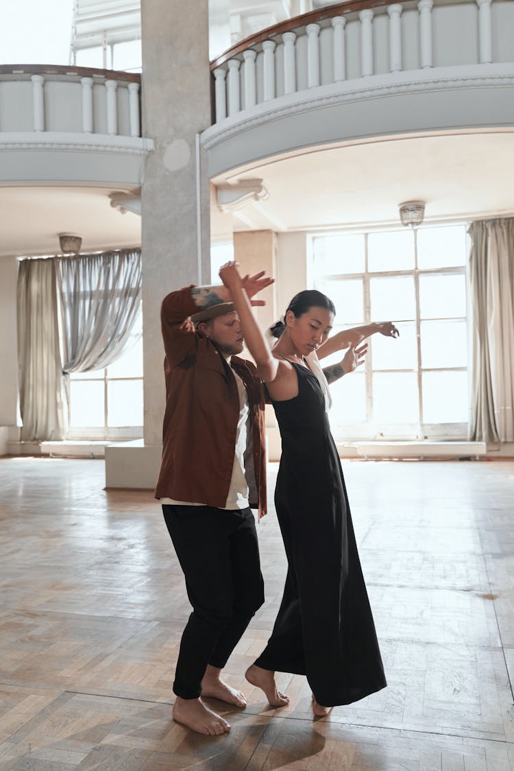 Man In Brown Shirt Dancing With A Woman In Black Dress