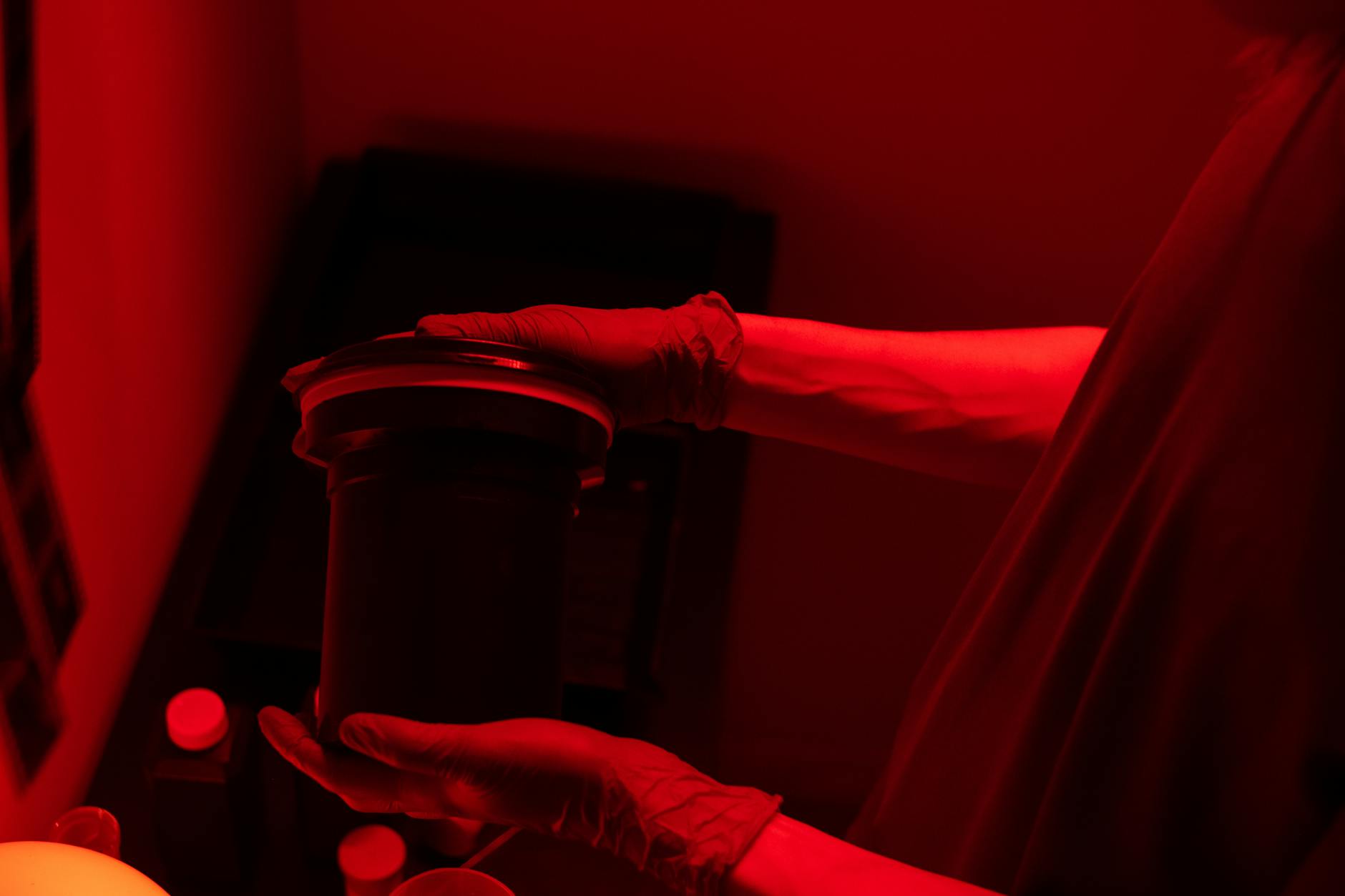 Man Holding Lens in Red Light