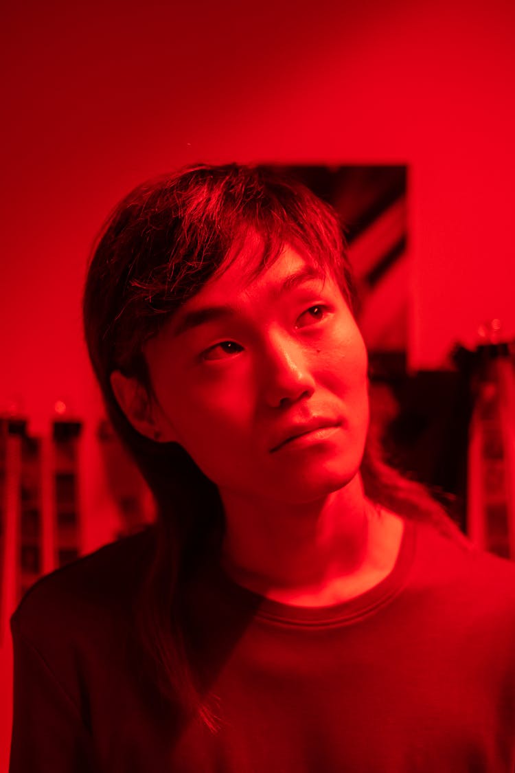 Young Man In Red Room With Photos And Camera Films In Background