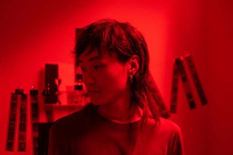 Woman In A Darkroom With Hanging Cut Films In The Background