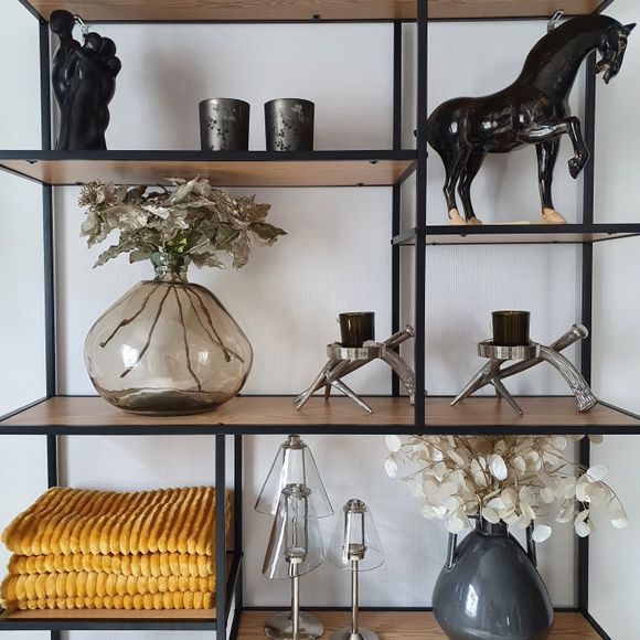 Open timber and steel shelf unit styled with vases, candle holders and folded throws — photo by Chadi on Pexels