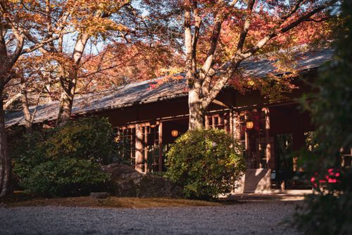 Free Charming Japanese house surrounded by vibrant autumn trees in Kyoto's tranquil setting. Stock Photo