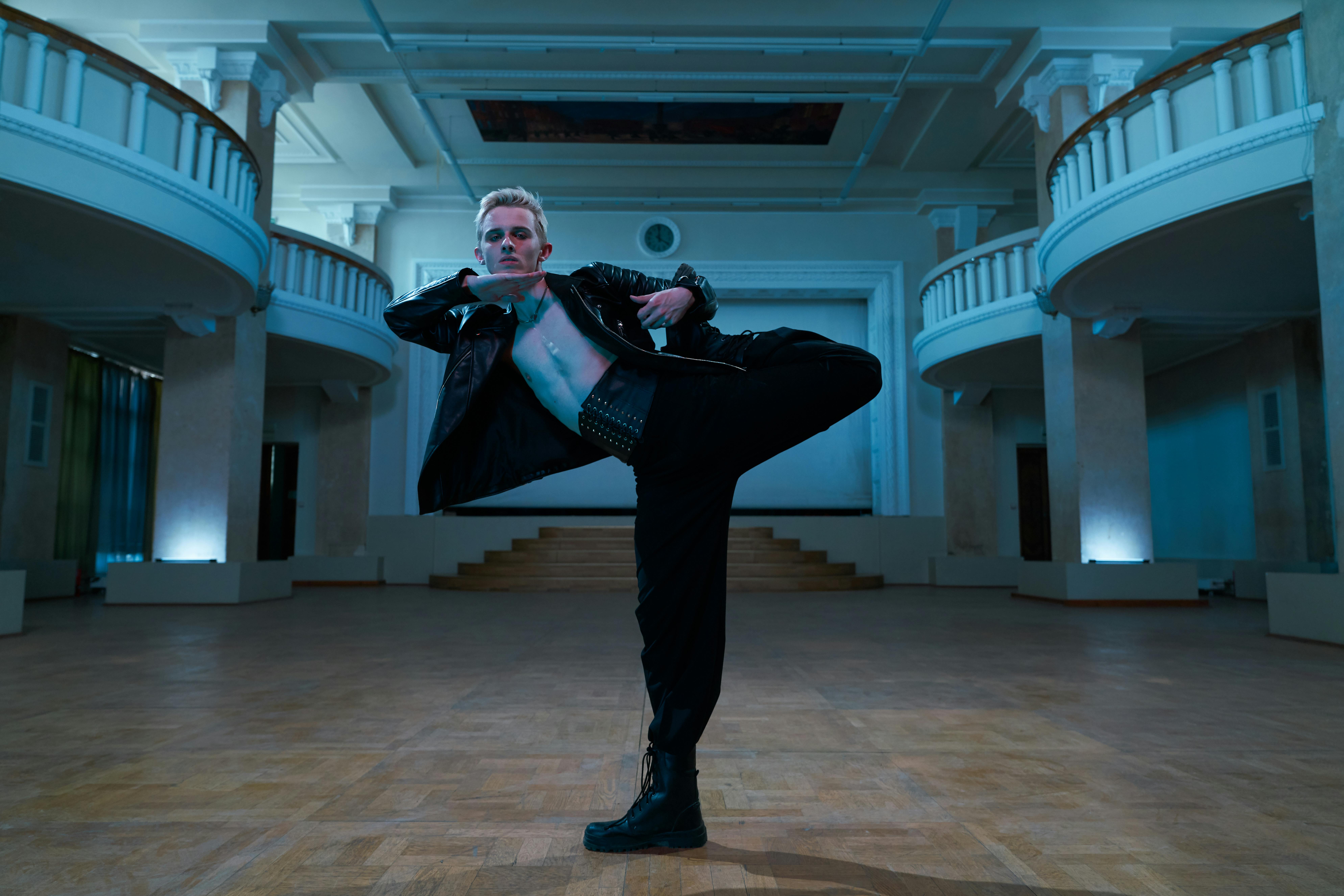 Free Contemporary dancer in a dynamic pose wearing a leather jacket in an elegant indoor setting. Stock Photo