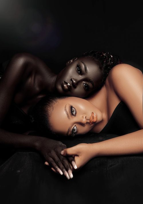 Free Artistic portrait of two women lying close together on a dark background, showcasing beauty and connection. Stock Photo