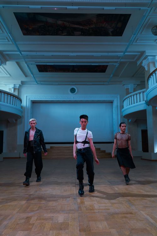 Free Three dancers performing in a spacious, classical hall with architectural details. Stock Photo