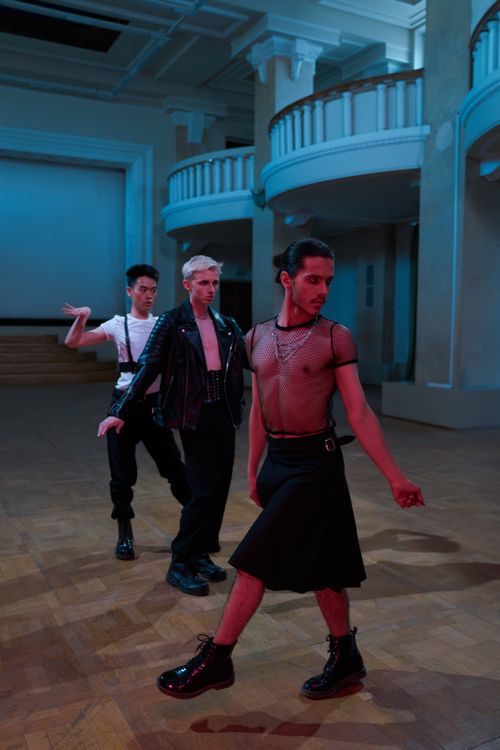 Free Three male dancers in stylish outfits performing in an elegant hall. Stock Photo