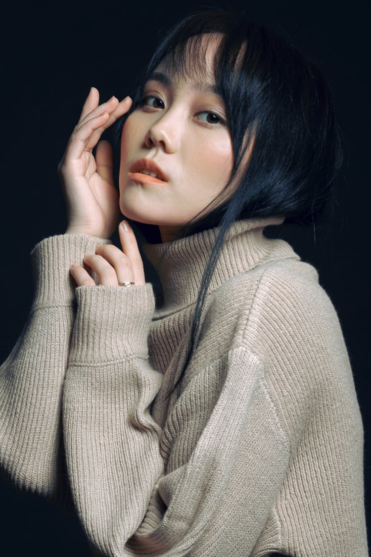 Asian Woman With Long Black Hair in Beige Golf Sweater