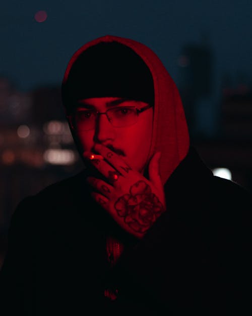 A Man in a Hoodie Smoking a Cigarette